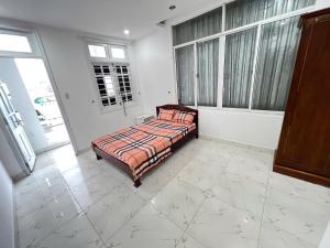 a bedroom with a bed in a room with windows at 59 Nguyễn Hiền Phòng ban công có một giường in Vung Tau