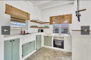 a kitchen with white counters and green cabinets at villa suiker tuintje in Kralendijk