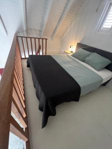 a bedroom with a bed with a black blanket on it at villa suiker tuintje in Kralendijk