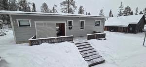 a house is covered in snow with some stairs at Tellervo in Syöte +4 photos