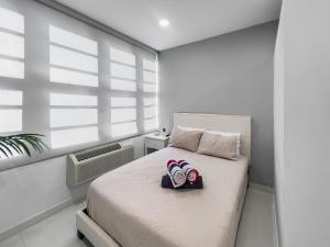 a bedroom with a bed with two pairs of slippers on it at Condado Studio with Pool Walk to Beach n Dining in San Juan +10 photos