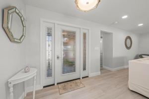 een woonkamer met witte muren en een spiegel bij Tranquil Tides in Sanibel Island +99 foto's