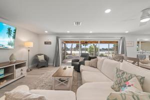 een woonkamer met een witte bank en een tafel bij Tranquil Tides in Sanibel Island