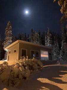 Ein Haus im Schnee bei Nacht mit dem Mond in der Unterkunft Tellervo in Syöte + 3 Fotos