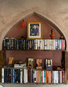 a book shelf with books and pictures on it at lake view, comfortable artistic design in Ouirgane