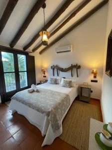 a bedroom with a large white bed in a room at Hotel Rural Hacienda de Ronda in Ronda