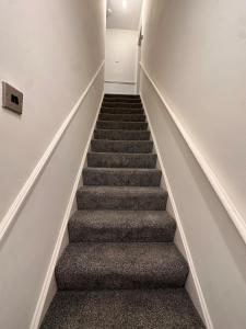 a staircase with grey carpeting and a stair case at 1 bed flat, free parking, 10 mins BHX airport, free WiFi in Widney Manor Station +1 photo