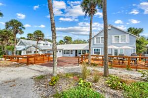 a house on the beach with palm trees at Gulf Front Escape on the Beach with Shared Lounging Deck & Pool in Englewood