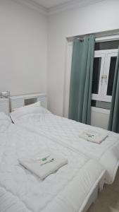 a white bed with two towels on top of it at شقة جميلة مطلة على الشاطيLuxury MUSCAT Apartment with Sea View in Ḩayl Āl ‘Umayr