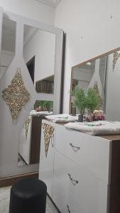 a bathroom with a white dresser and a mirror at شقة جميلة مطلة على الشاطيLuxury MUSCAT Apartment with Sea View in Ḩayl Āl ‘Umayr +5 photos