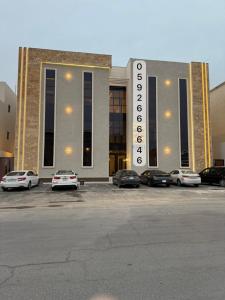 哈费尔巴廷شقة Vip عائلية وصول ذاتي的一座大型建筑物，停车场里停满了汽车