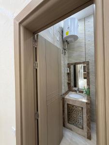 ein Badezimmer mit Waschbecken und Spiegel in der Unterkunft Arabian Sea Marina - مرسى بحر العرب in Sur
