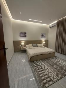 a bedroom with a large bed and a rug at شقة Vip عائلية وصول ذاتي in Hafr Al-Batin