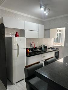 a kitchen with a refrigerator and a counter top at Apartamento canto do forte in Praia Grande