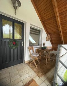un portico con porta nera, tavolo e sedie di All Homes Apartments a Bad Schallerbach