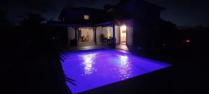 a swimming pool at night with purple lights at Villa Luciole Man'Néa in Sainte-Anne