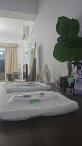 a room with three beds with towels and a plant at شقة جميلة مطلة على الشاطيLuxury MUSCAT Apartment with Sea View in Ḩayl Āl ‘Umayr
