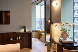 Locke Copenhagen في كوبنهاغن: غرفة معيشة مع طاولة مع إناء من الزهور