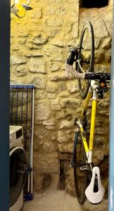 Una bicicleta amarilla estacionada junto a una pared de piedra. en ASTOR - La Dolce Vita the Tuscan way, en Montecatini Val di Cecina