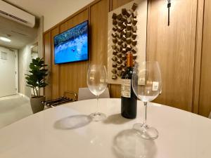 Dos copas de vino sobre una mesa con una botella de vino. en Hotel Bourbon - Quarto 1603 - Beira Mar de Fortaleza - Vista Mar, en Fortaleza