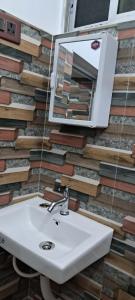 ein Badezimmer mit Waschbecken und Spiegel in der Unterkunft Diya STAYS in Rāmpur Hāt + 21 Fotos