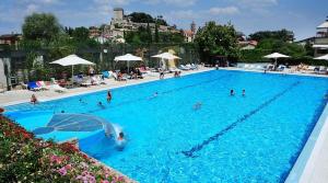 a large blue swimming pool with people in it at Villa Bagno Santo in Sarteano
