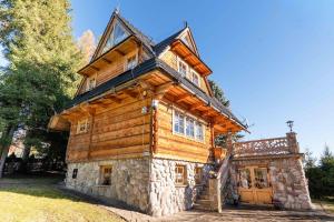 a log cabin house with a stone facade at Willa Szept Giewontu-Mountain Base in Kościelisko