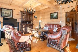 a living room with leather furniture and a fireplace at Willa Szept Giewontu-Mountain Base in Kościelisko