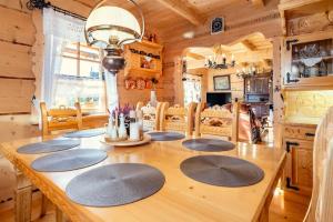 a dining room with a wooden table in a cabin at Willa Szept Giewontu-Mountain Base in Kościelisko