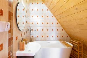 a bathroom with a white tub and a sink at Willa Szept Giewontu-Mountain Base in Kościelisko +32 photos
