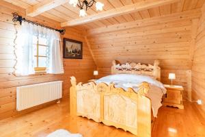 a bedroom with a bed in a log cabin at Willa Szept Giewontu-Mountain Base in Kościelisko