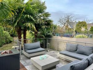 a patio with two couches and a coffee table at Sonnendeck - Wellness Whirlpool Garden & Grill,125qm in Meerbusch