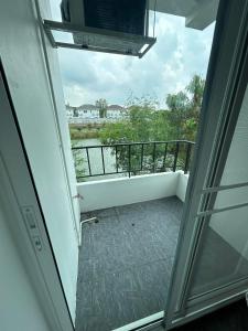 una puerta abierta a un balcón con vistas en Comfy Hotels Share Bathroom คอมฟี่ โฮเทล ห้องน้ำรวม ซอยกิ่งแก้ว 31ก, en Samutprakarn