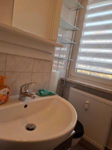 ein Badezimmer mit Waschbecken und Fenster in der Unterkunft FeWo s Runde Wiese LL in Greifswald