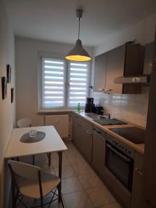 eine Küche mit einem Tisch und einem kleinen Tisch mit Stühlen in der Unterkunft FeWo s Runde Wiese LL in Greifswald + 13 Fotos