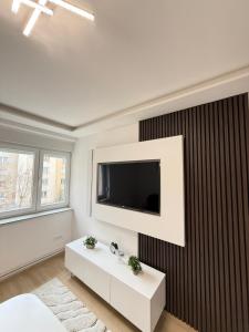 ein Wohnzimmer mit einem Fernseher an der Wand in der Unterkunft Stan Sarajevo in Sarajevo