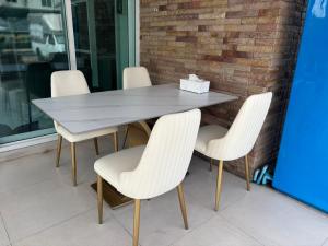a table with white chairs and a box on it at The Sceneสุพรรณบุรี in Suphan Buri