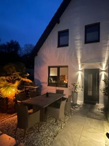 a patio with a table and chairs in front of a building at Sonnendeck - Wellness Whirlpool Garden & Grill,125qm in Meerbusch