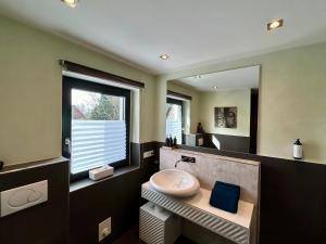 a bathroom with a sink and a mirror at Sonnendeck - Wellness Whirlpool Garden & Grill,125qm in Meerbusch +36 photos