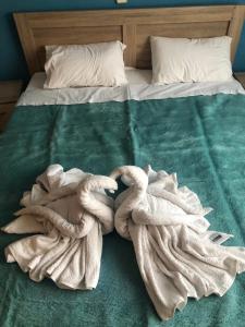 un letto con una coperta verde e due asciugamani di kb apartment Drama a Drama