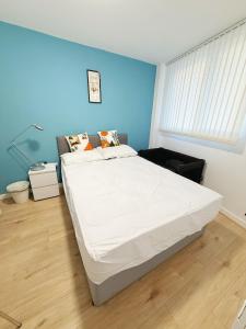a bedroom with a large bed with a blue wall at City Center Balcony by the Universities in Manchester