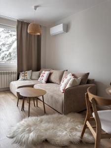 a living room with a couch and a table at Apartament Cicha Przystań w centrum Zakopanego APARTZAKOP in Zakopane