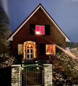 Una casa con luces en las ventanas. en Kleine Landhaus-Perle am Schlosspark, en Eutin