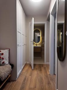 a hallway with a mirror and a dressing room at Apartament Cicha Przystań w centrum Zakopanego APARTZAKOP in Zakopane