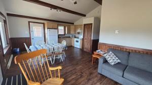a living room with a couch and a table and chairs at Chalets l'Acadien sur mer in Petit Rocher
