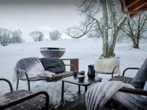 a snow covered patio with two chairs and a table at Chalet RevAlp - OVO Network in Combloux