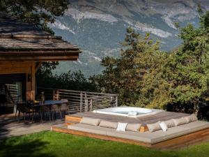a jacuzzi tub sitting on a deck next to a house at Chalet RevAlp - OVO Network in Combloux