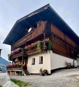 Una casa con flores al costado. en Talgenbichl, en Bruck am Ziller