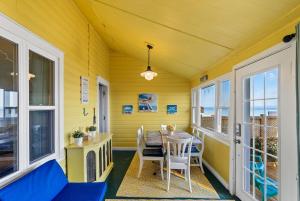 een eetkamer met een tafel, stoelen en ramen bij Crystal Beach Stunning Waterfront Stay with Fire Pit in Fort Erie