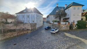 two cars parked in a parking lot next to a building at Hotel Garni Villa Areka in Český Krumlov